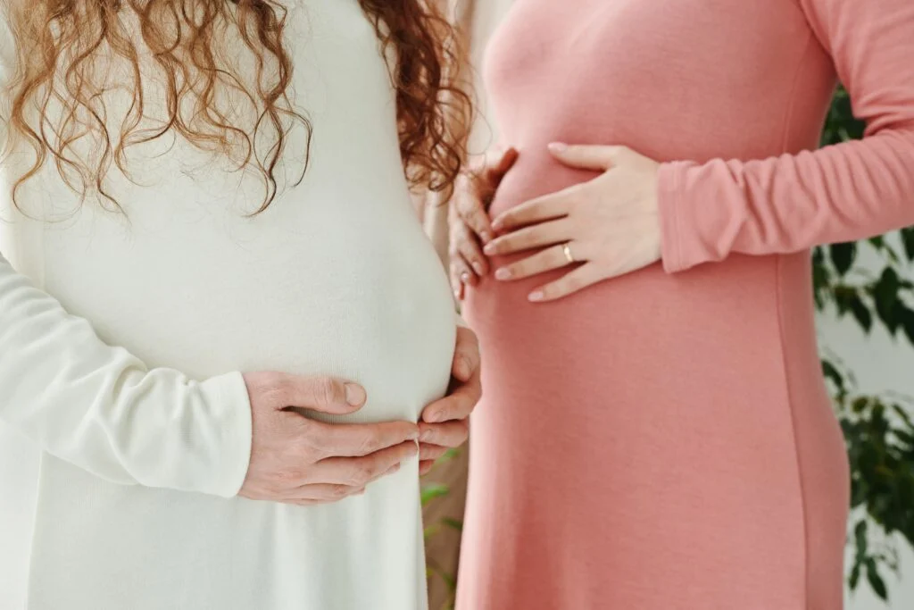 Two pregnant women holding their bumps